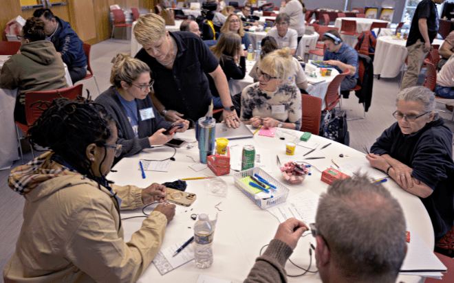 Laurie Dale helps a person build a switch during a technology event.
