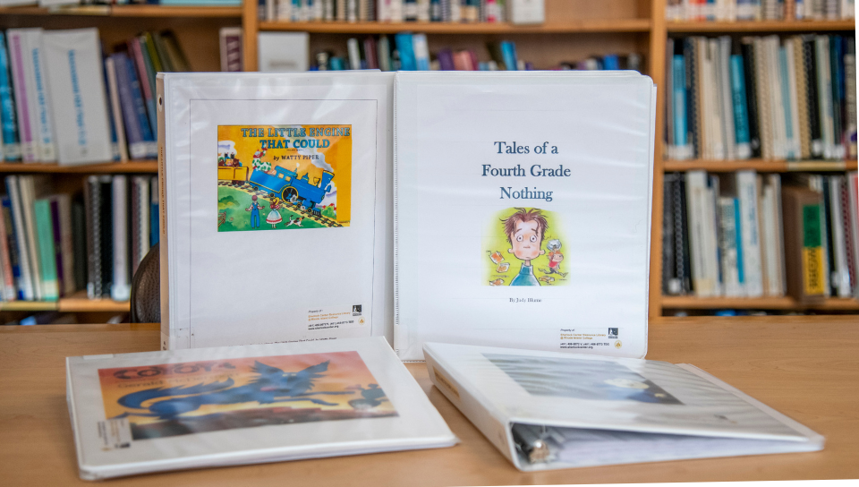 Some of the Sherlock Center’s adapted literature titles are shown, including “The Little Train That Could” and “Tales of a Fourth Grade Nothing.” 