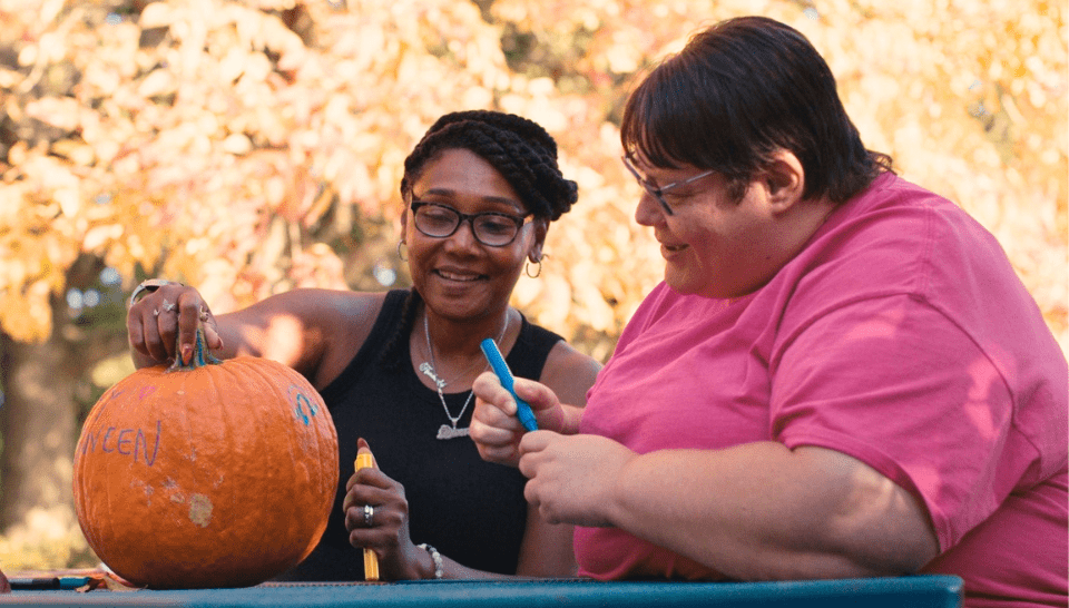 Veronica Schenk and Kim Weeks paint a pumpkin.