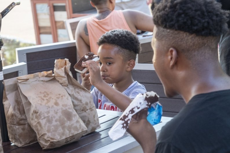 A young child eats an ice cream sandwich.