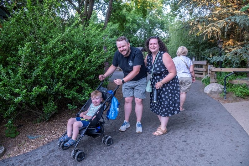 Parents and their child in a stroller enjoy the zoo after the program.