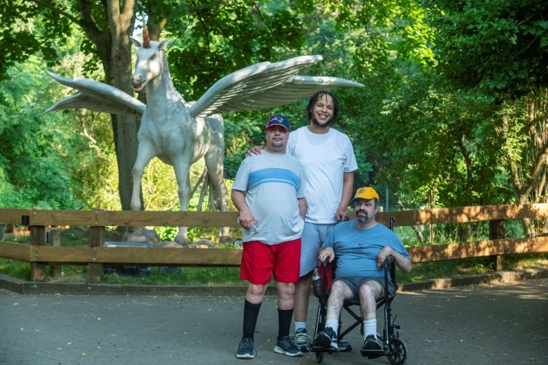 Three guests pose in front of a unicorn that’s part of a special “Dragons and Mythical Creatures” exhibition at the zoo.