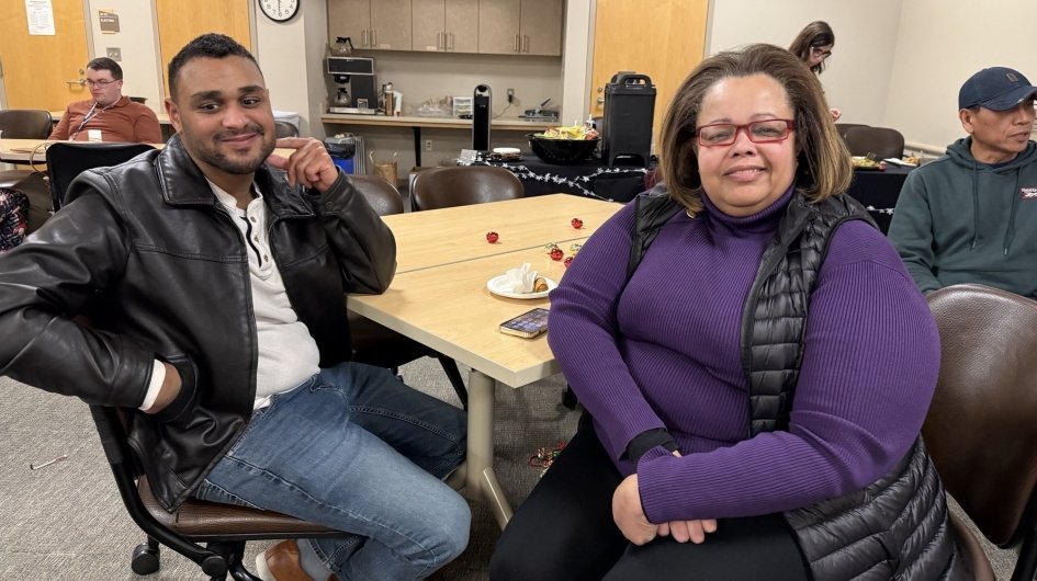 Two people at a table smile at Jingle Mingle.