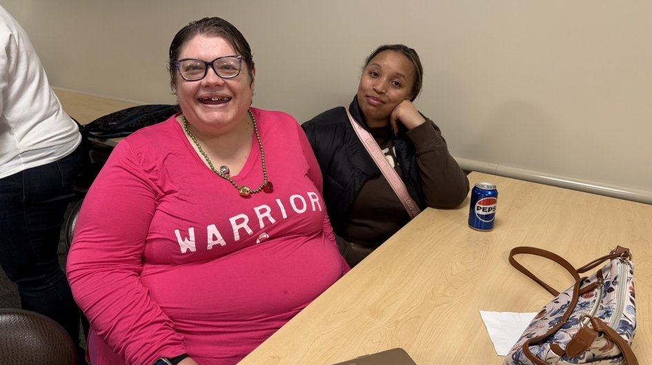 Two people at a table smile at Jingle Mingle.