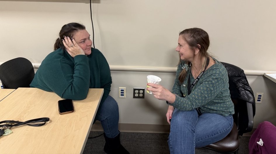 Two people talk at Jingle Mingle.