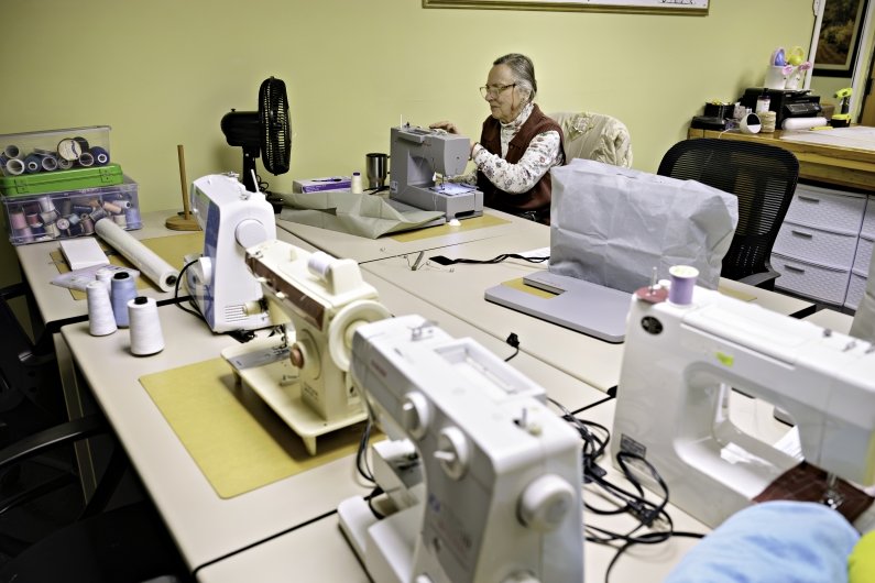 A woman sews in the craft room.