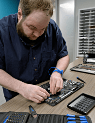 Nathan Markley works on the internal parts of a laptop at RIPIN.