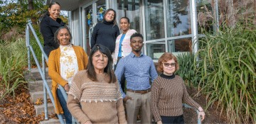 Members of the Educational Advocate Program stand on the stairway outside the Sherlock Center on Disabilities at Rhode Island College.