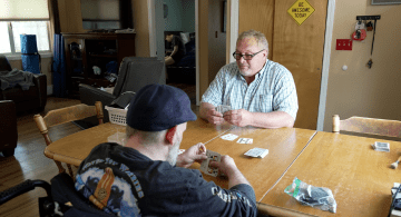 Two men play cards at a table.