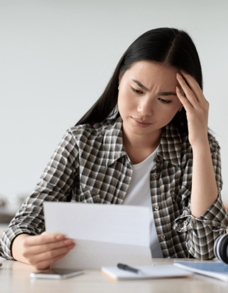A woman reading a letter looks concerned.