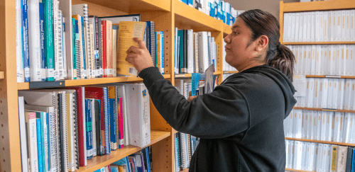 A Sherlock Center student worker shelves books in the center's lending library.