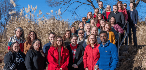 Staff members gather on the stairs alongside the Sherlock Center on the RIC campus,