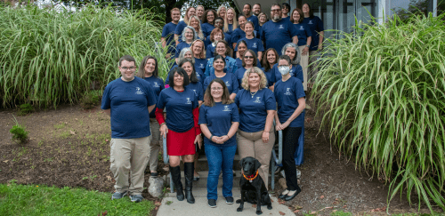 Group shot of Sherlock Center staff with Elvy, RIC's comfort K9.