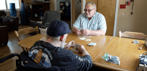 Two men play cards at a table.