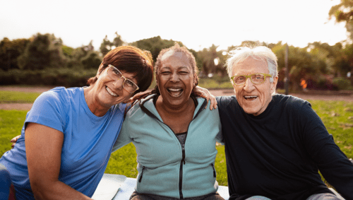 Two women and a man outside, laughing