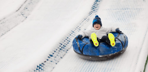 A child enjoys tubing on a winter day.