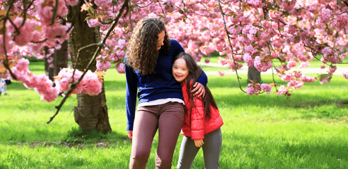 A mother and child in colorful pink blooming trees.