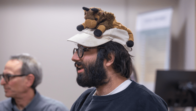 Malcolm Streitfeld, a RIC undergraduate anthropology major and autistic self-advocate, speaks to a class while wearing a hat with a stuffed buffalo he named Apple Crisp.