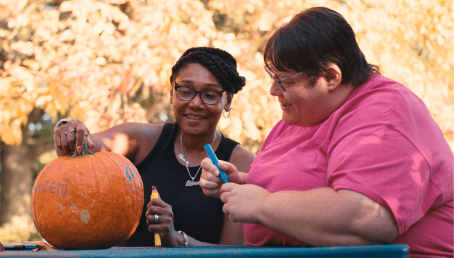 Veronica Schenk and Kim Weeks paint a pumpkin.