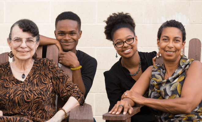 A multigenerational African American family is pictured outside.